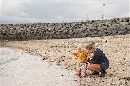 Mother and toddler crouching at waters edge Stock Photo - Premium Royalty-Free, Code: 649-07063821