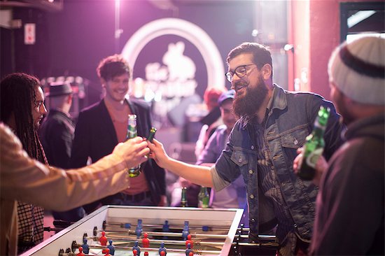 Group of friends and table football game in bar Stock Photo - Premium Royalty-Free, Image code: 649-07063887