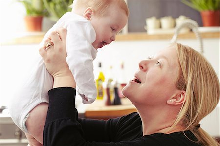 family playing in the kitchen - Mother holding baby mid air Stock Photo - Premium Royalty-Free, Code: 649-07118176