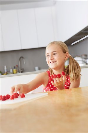 raspberry fingers - Girl putting raspberries on fingers Stock Photo - Premium Royalty-Free, Code: 649-07118292