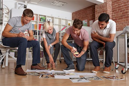 Colleagues in meeting looking at papers on floor Stockbilder - Premium RF Lizenzfrei, Bildnummer: 649-07118362