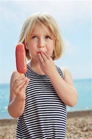 simsearch:649-07118498,k - Child with fingers on lip holding ice lolly Photographie de stock - Premium Libres de Droits, Code: 649-07118485