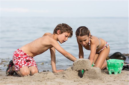 Brother and sister on beach building sandcastle Photographie de stock - Premium Libres de Droits, Code: 649-07118653