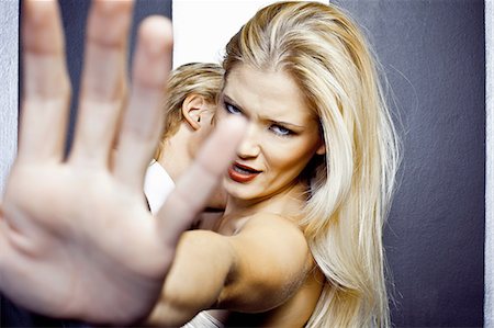 simsearch:649-07118888,k - Close up of young angry woman with hand in front of camera Fotografie stock - Premium Royalty-Free, Codice: 649-07118856