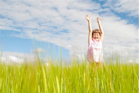 reaching sky - Girl in field with arms raised Stock Photo - Premium Royalty-Free, Code: 649-07118974