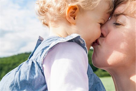 family outdoors candid - Mother kissing daughter Stock Photo - Premium Royalty-Free, Code: 649-07118981