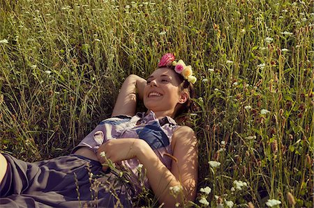 simsearch:649-08381608,k - Young woman lying in meadow with flowers in her hair Photographie de stock - Premium Libres de Droits, Code: 649-07119074