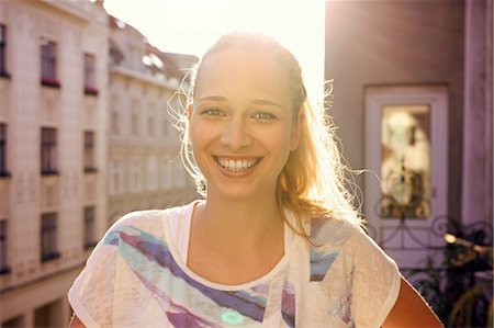 europe city and vacation - Portrait of young woman standing on city apartment balcony Stock Photo - Premium Royalty-Free, Code: 649-07119080