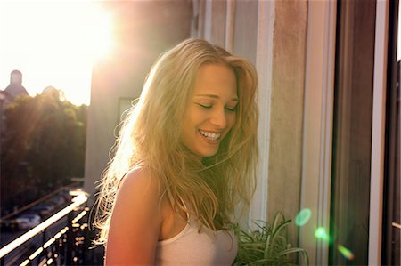 Young woman standing on city apartment balcony Foto de stock - Sin royalties Premium, Código: 649-07119081