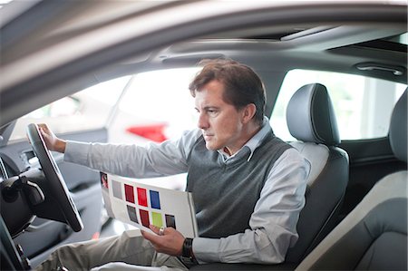 shopper (male) - Mid adult man checking dashboard in car showroom Stock Photo - Premium Royalty-Free, Code: 649-07119134