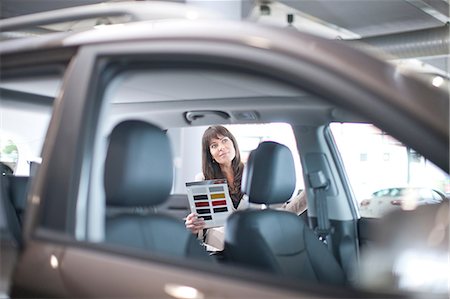 simsearch:649-07119135,k - Mid adult woman with color swatch in car showroom Photographie de stock - Premium Libres de Droits, Code: 649-07119130