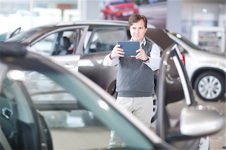 phone car showroom - Mid adult man photographing car in showroom Foto de stock - Sin royalties Premium, Código: 649-07119141