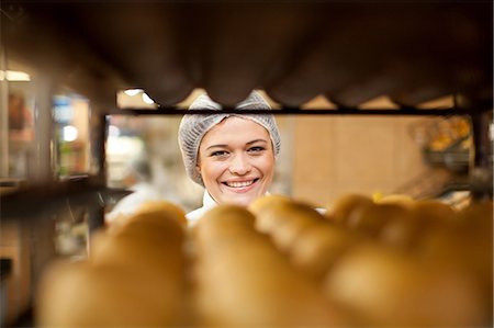 Portrait of young baker and tray of bread rolls Foto de stock - Sin royalties Premium, Código: 649-07119162
