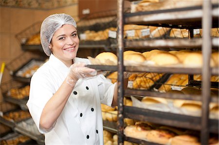 server - Portrait of young baker holding tray of bread rolls Photographie de stock - Premium Libres de Droits, Code: 649-07119163