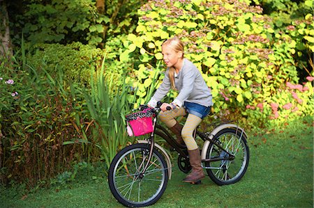 rouler (véhicule) - Young girl riding bicycle in garden Photographie de stock - Premium Libres de Droits, Code: 649-07119208