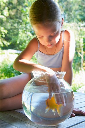 simsearch:649-07804173,k - Young girl with fingers in goldfish bowl Foto de stock - Sin royalties Premium, Código: 649-07119210