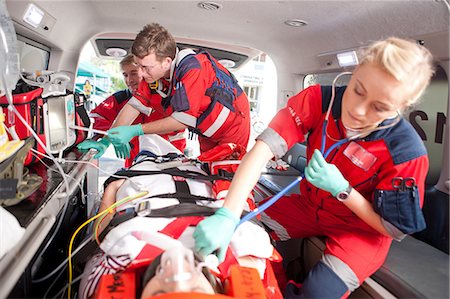 simsearch:649-07119232,k - Paramedics using stethoscope on patient in ambulance Stock Photo - Premium Royalty-Free, Code: 649-07119228