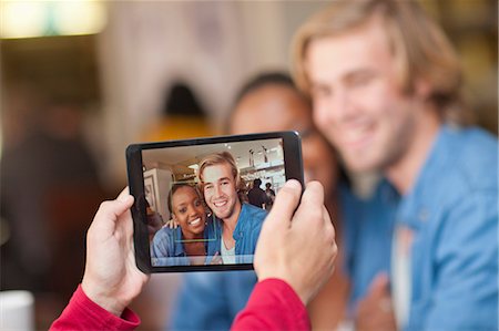 Group of friends in cafe photographing with digital tablet Stock Photo - Premium Royalty-Free, Code: 649-07119254