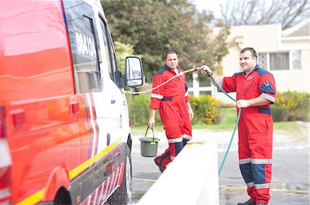 Paramedics cleaning ambulance with hosepipe Fotografie stock - Premium Royalty-Free, Codice: 649-07119250