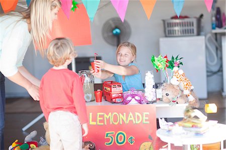 Two young sisters selling drink to mother from stall Foto de stock - Sin royalties Premium, Código: 649-07119281