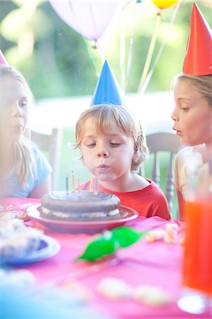 Brother and his sisters enjoying birthday party Stock Photo - Premium Royalty-Free, Code: 649-07119292