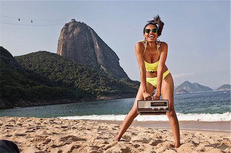 Woman on beach with vintage radio, Rio de Janeiro, Brazil Stock Photo - Premium Royalty-Free, Code: 649-07119354