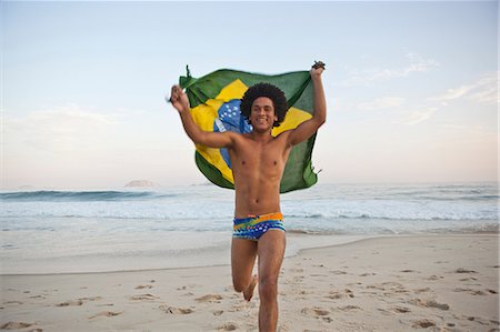 Young man running on beach with Brazilian Flag Stockbilder - Premium RF Lizenzfrei, Bildnummer: 649-07119419