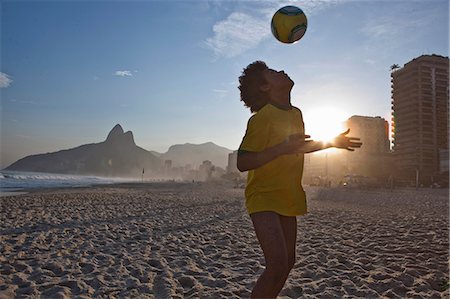 Young man heading football, Ipanema Beach, Rio, Brazil Stock Photo - Premium Royalty-Free, Code: 649-07119413