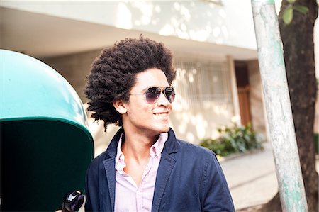 Young man in sunglasses by pay telephone Stock Photo - Premium Royalty-Free, Code: 649-07119447