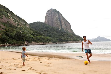 playing soccer - Father and son playing football on beach, Rio de Janeiro, Brazil Stock Photo - Premium Royalty-Free, Code: 649-07119658