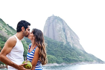 Couple kissing on beach with Sugarloaf Mountain, Rio de Janeiro, Brazil Stock Photo - Premium Royalty-Free, Code: 649-07119653