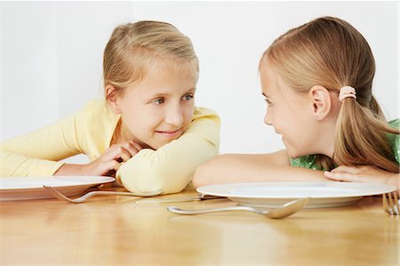preteen plate - Two girls leaning on table with empty plates Stock Photo - Premium Royalty-Free, Code: 649-07119714