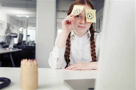 self adhesive note - Girl in office with adhesive notes covering eyes, peeking Photographie de stock - Premium Libres de Droits, Code: 649-07119764