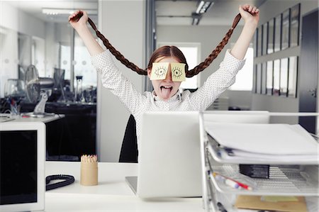 Girl in office with adhesive notes covering eyes holding plaits Photographie de stock - Premium Libres de Droits, Code: 649-07119765