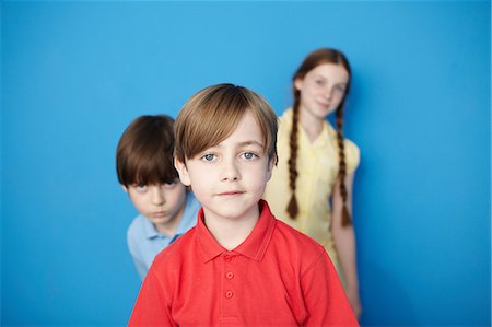 elementary schoolchild - Portrait of three children looking at camera, blue background Photographie de stock - Premium Libres de Droits, Code: 649-07119797