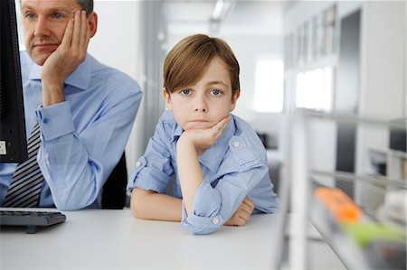 paper work - Boy leaning on elbow, father using computer Photographie de stock - Premium Libres de Droits, Code: 649-07119809