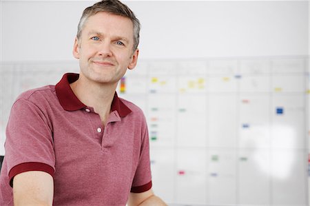 smiling office worker - Man sitting in office looking at camera Stock Photo - Premium Royalty-Free, Code: 649-07238284