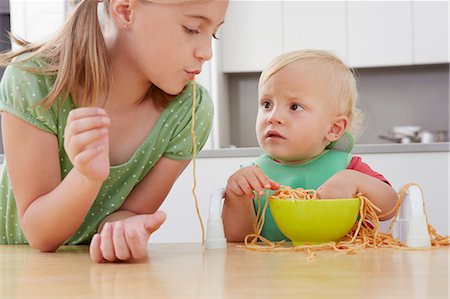 spaghetti - Girl and toddler playing with spaghetti Photographie de stock - Premium Libres de Droits, Code: 649-07238337