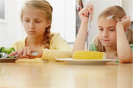 foods kids - Girls poking vegetables on plate Stock Photo - Premium Royalty-Free, Code: 649-07238340