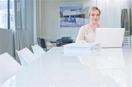 dificuldades - Woman sitting at conference room table using laptop Foto de stock - Sin royalties Premium, Código: 649-07238396