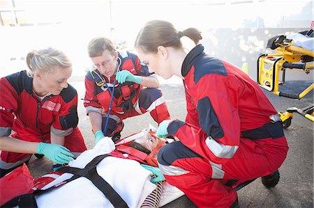 paramedic - Three paramedics with patient on stretcher wearing oxygen mask Foto de stock - Sin royalties Premium, Código: 649-07238430