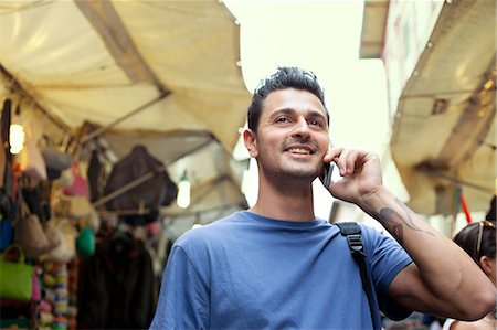 simsearch:649-07238579,k - Young man on cell phone, San Lorenzo market, Florence, Tuscany, Italy Stock Photo - Premium Royalty-Free, Code: 649-07238563