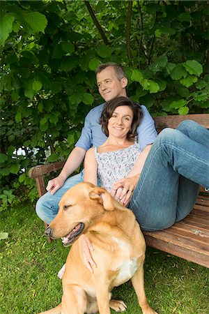 simsearch:649-07239579,k - Mature couple sitting on garden bench with dog Foto de stock - Sin royalties Premium, Código: 649-07238618