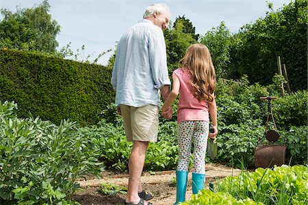 Grandfather and granddaughter holding hands in garden Stock Photo - Premium Royalty-Free, Code: 649-07238613