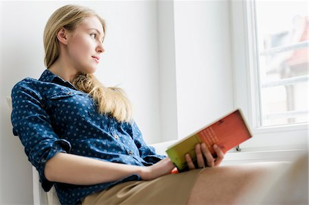 Girl looking up from book Photographie de stock - Premium Libres de Droits, Code: 649-07238836