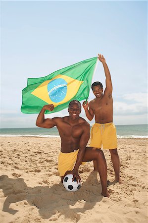 Men posing with brazilian flag on beach Stock Photo - Premium Royalty-Free, Code: 649-07238854