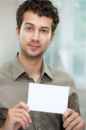 simsearch:649-07238264,k - Young man holding white card Foto de stock - Sin royalties Premium, Código: 649-07238904