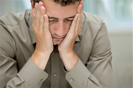 Young man covering cheeks with hands Photographie de stock - Premium Libres de Droits, Code: 649-07238905