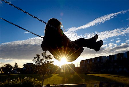 silhouette child - Young girl on swing at sunset Stock Photo - Premium Royalty-Free, Code: 649-07238927