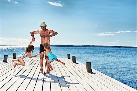 family on pier - Father and daughters playing on pier, Utvalnas, Gavle, Sweden Stock Photo - Premium Royalty-Free, Code: 649-07238985